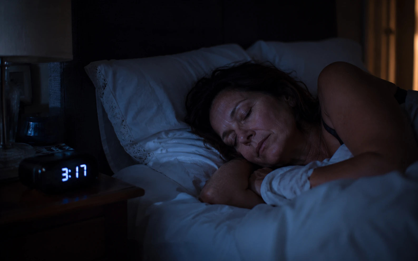 Woman sleeping soundly, clock past 3AM